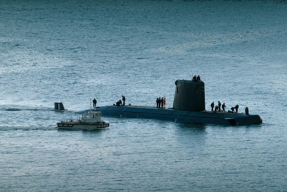 Submarino de la Armada española con oficiales y marineros en cubierta durante maniobras navales.