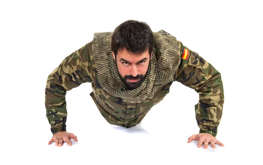 Militar español realizando flexiones con uniforme de camuflaje para entrenar las pruebas físicas de Tropa y Marinería.