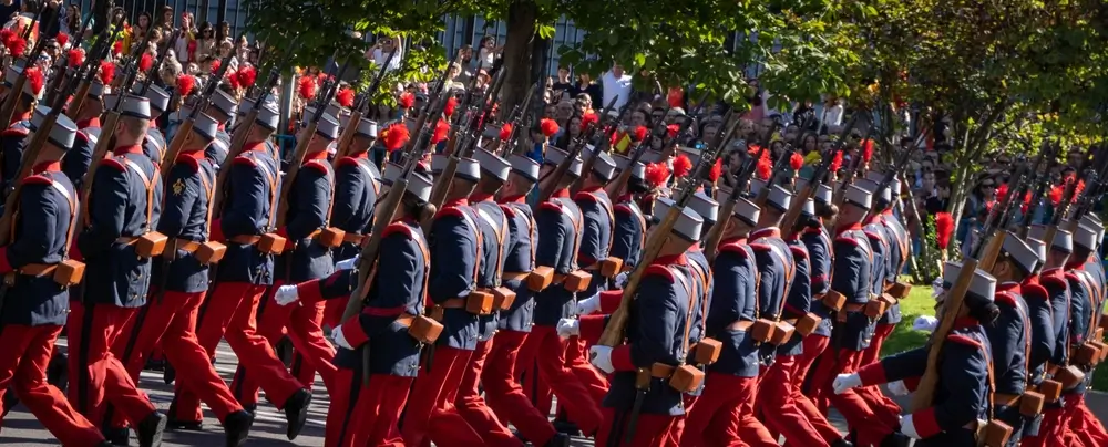 Militares españoles en formación durante un desfile, mostrando la disciplina y el orden del escalafón militar.
