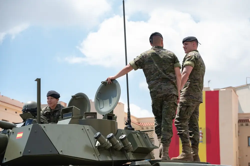 Reservistas voluntarios españoles en un entrenamiento militar sobre un tanque blindado durante su etapa de formación.