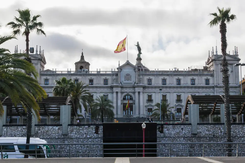 Fachada de la Delegación de Defensa con la bandera de España y palmeras, donde se tramitan solicitudes para reservistas.