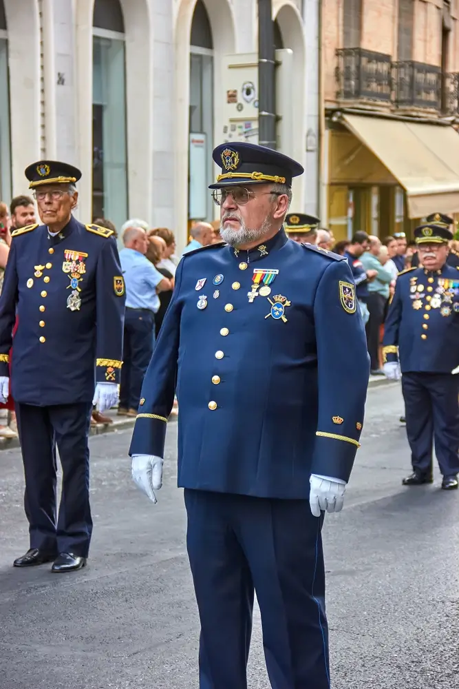 Oficiales de la Armada con uniforme azul de gala, destacando los galones dorados en las bocamangas y sus condecoraciones.
