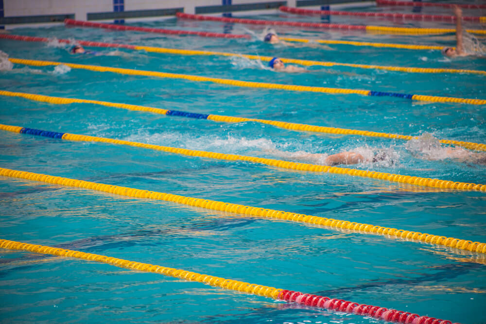 Nadadores en una piscina de competición durante la prueba de natación de 50 metros para el acceso militar.