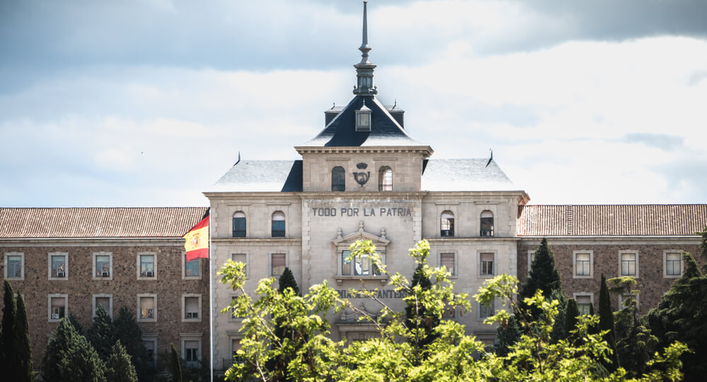 Fachada de la Academia General Militar de Zaragoza con la bandera de España y el lema Todo por la Patria.