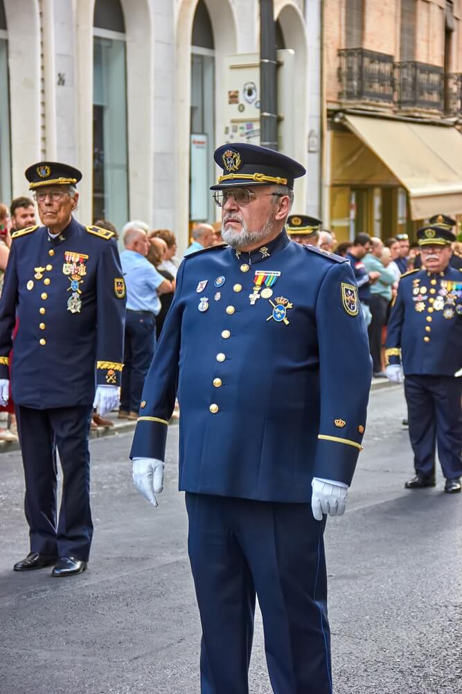Oficiales de la Armada con uniforme azul de gala, destacando los galones dorados en las bocamangas y sus condecoraciones.