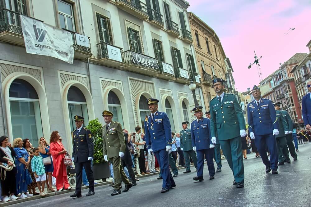 Militaires et policiers défilant en uniforme, illustrant les grades de la tabla sueldos militares.