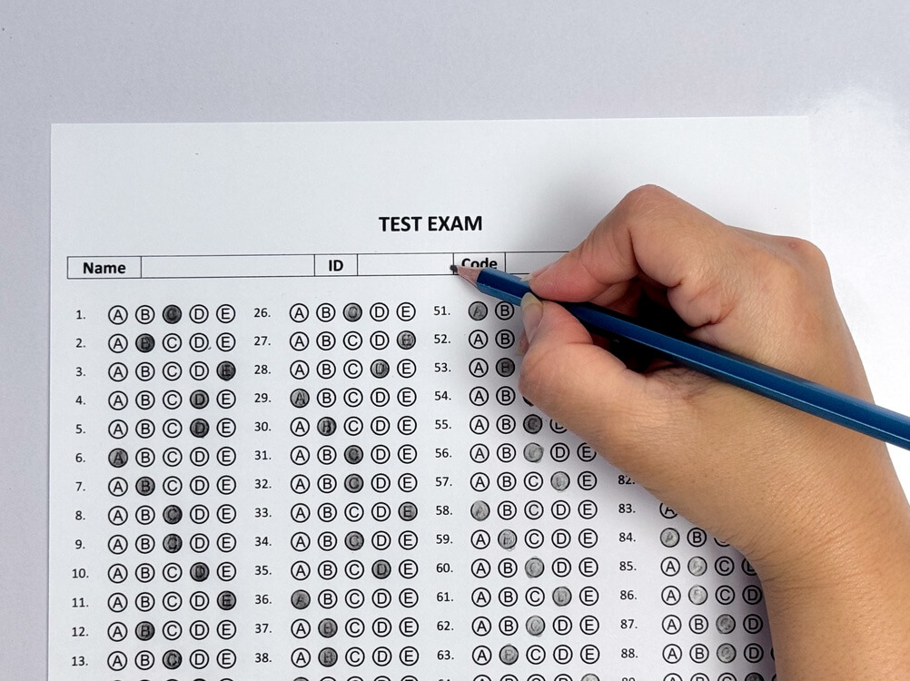 Aspirantes a suboficial completando una prueba escrita tipo test en sala de examen militar