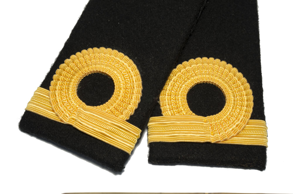 Hombreras y galones dorados de uniforme naval con insignias de rango de la Armada Española