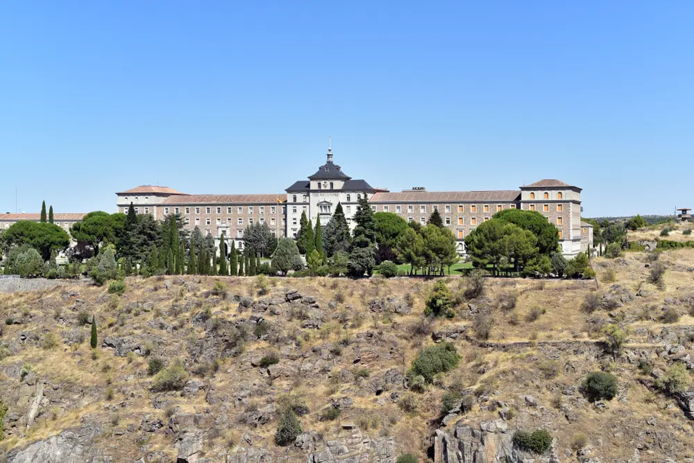 Edificio principal de estilo neomudéjar de una academia militar española rodeado de vegetación