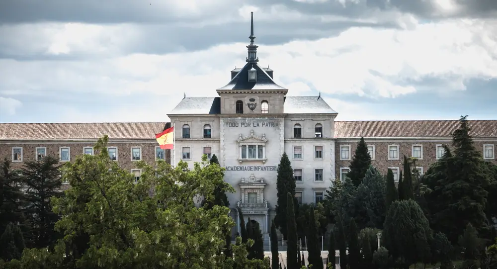 Instalaciones exteriores de una academia militar con patio de instrucción y edificios castrenses