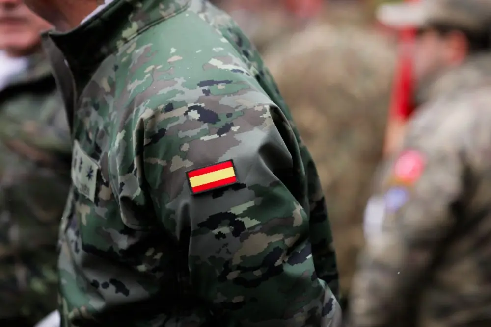 Uniforme militar con bandera de España para ilustrar la escala salarial y retribuciones de las Fuerzas Armadas.
