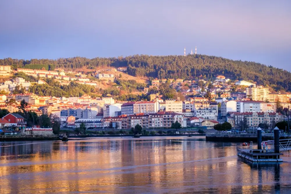 Vista de la base naval y Escuela Naval Militar de Marín junto al puerto en la ría de Pontevedra al atardecer.