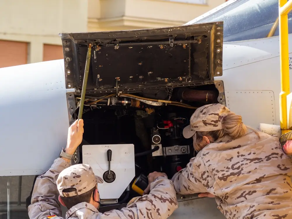 Técnico militar revisando aeronave en base aérea española durante mantenimiento aeronáutico