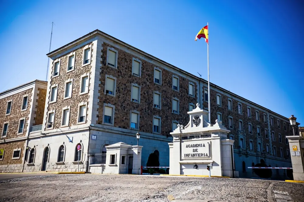 Edificio de la Academia de Infantería para la instrucción militar de cadetes con la bandera de España ondeando.