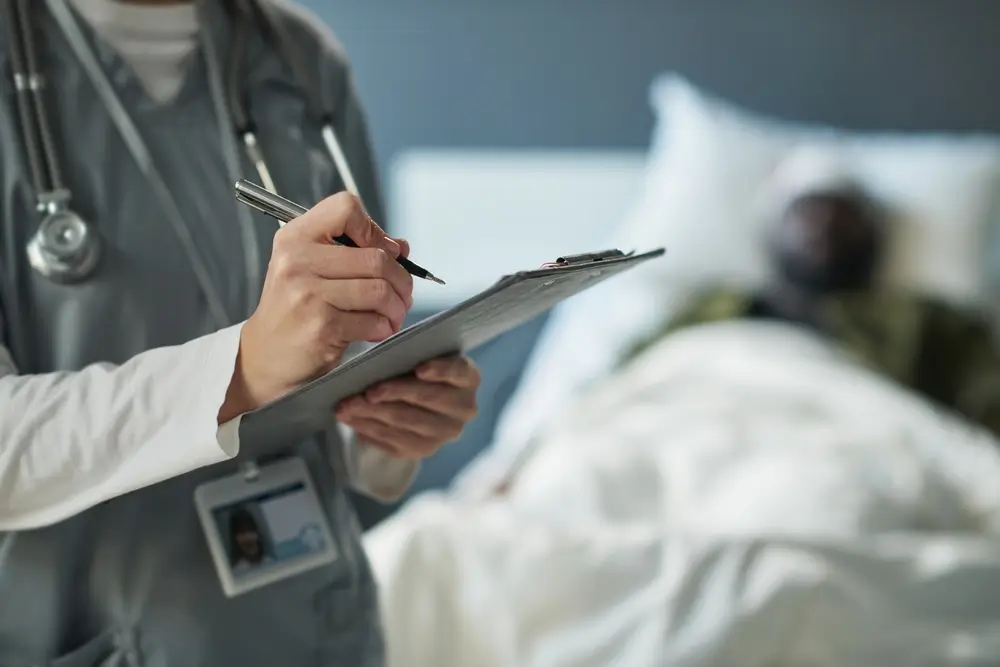 Sanitario militar rellenando documentos oficiales y el formulario de solicitud de oposición en un hospital.