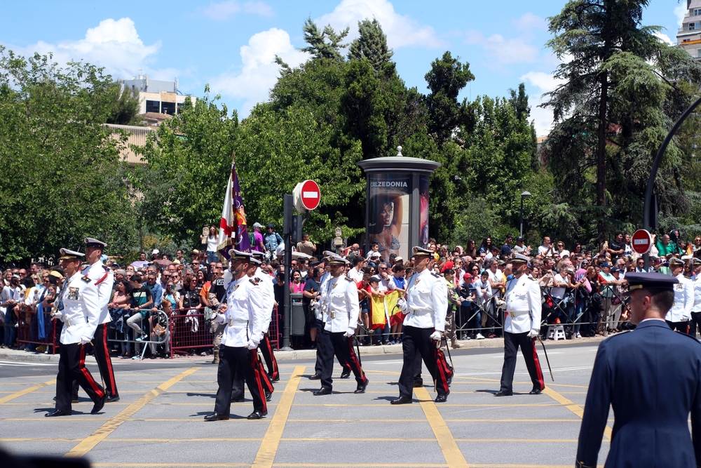 Oficiales de la Armada Española con uniforme de gala e insignias de rango doradas durante un desfile militar.