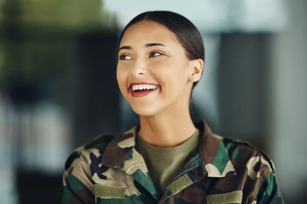 Joven recluta sonriente con uniforme de camuflaje en el proceso de selección de aspirantes militares.