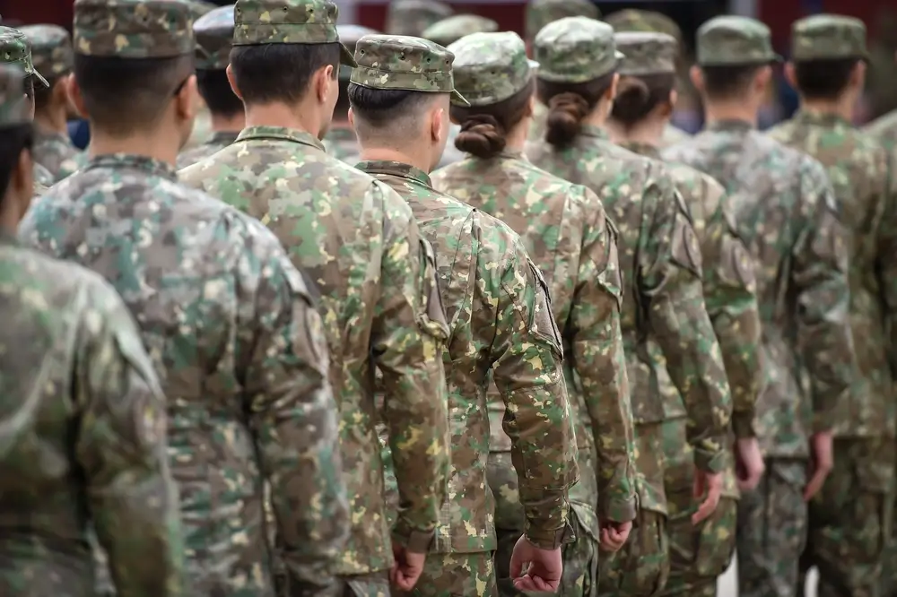 Soldados en formación con uniforme de camuflaje durante un proceso de reclutamiento para el Ejército español.