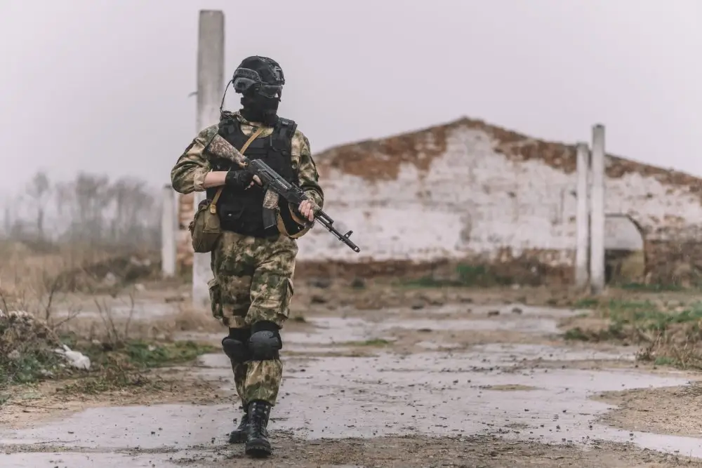 Soldado patrullando una base militar, reflejando el personal de tropa y marinería en instalaciones del ejército.