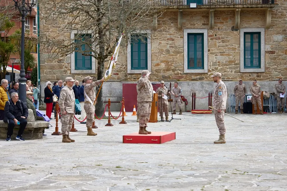 Oficial militar en uniforme recibiendo reconocimiento en ceremonia de ascenso ante formación de soldados
