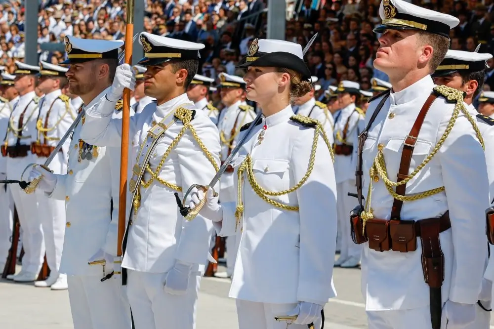 Estudiantes militares de la Armada con uniformes blancos de gala y sables en formación en la Escuela Naval Militar.