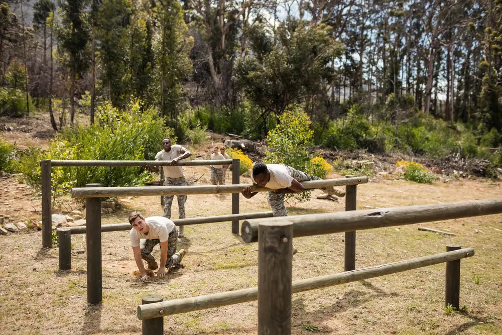 Soldados superando obstáculos de madera en un circuito de entrenamiento físico para la selección del Ejército.