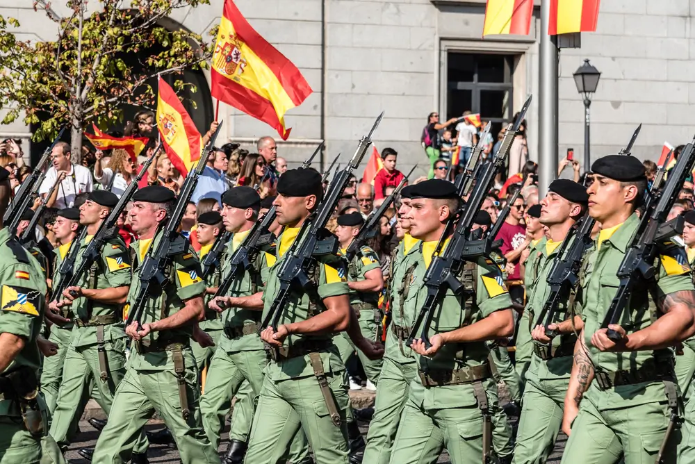 Soldados españoles de élite marchando con uniforme de la Legión y boina militar con su característico paso rápido.
